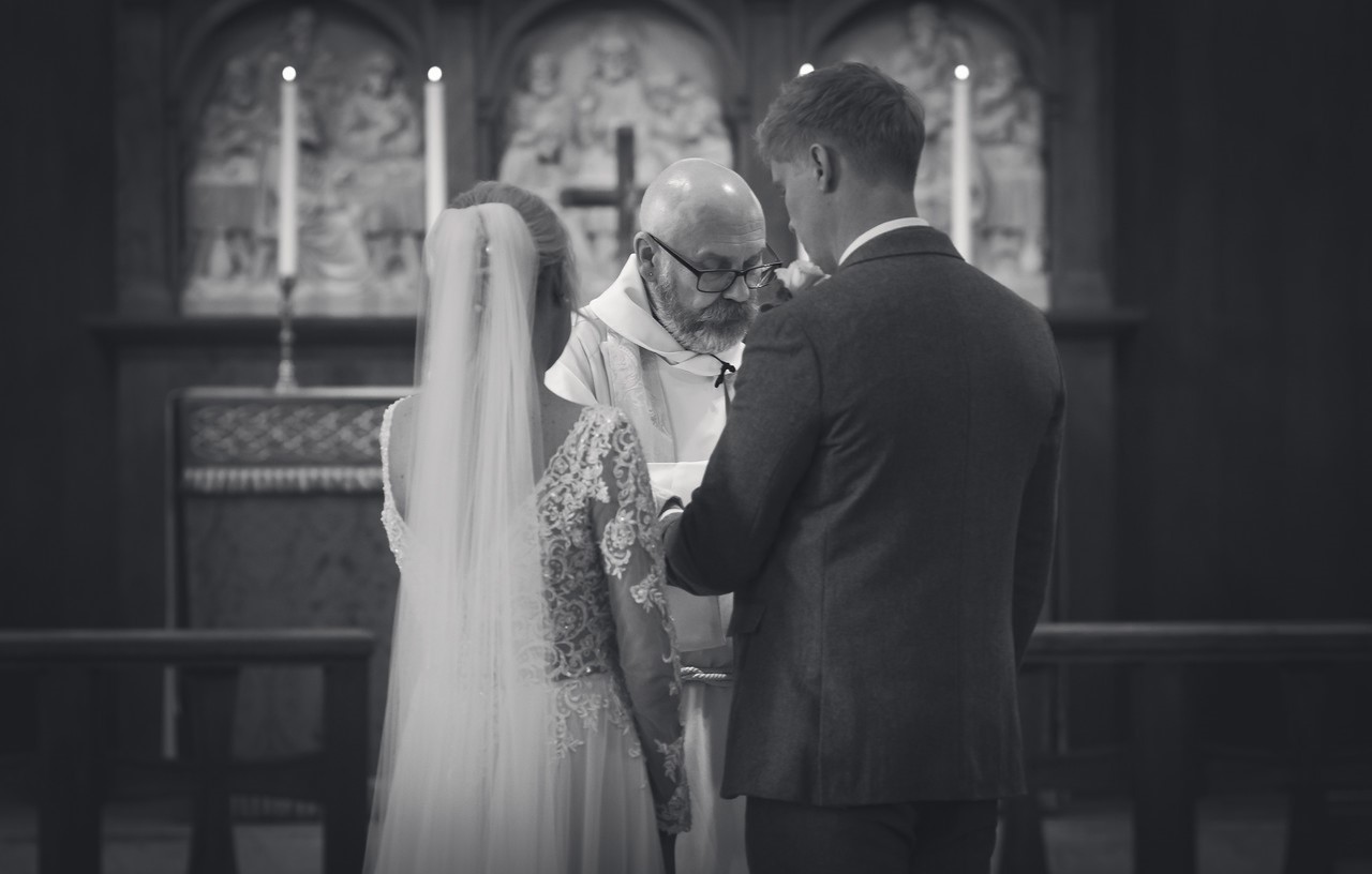 Wedding ServiceThe couple receiving a blessing by the priest at the high altar